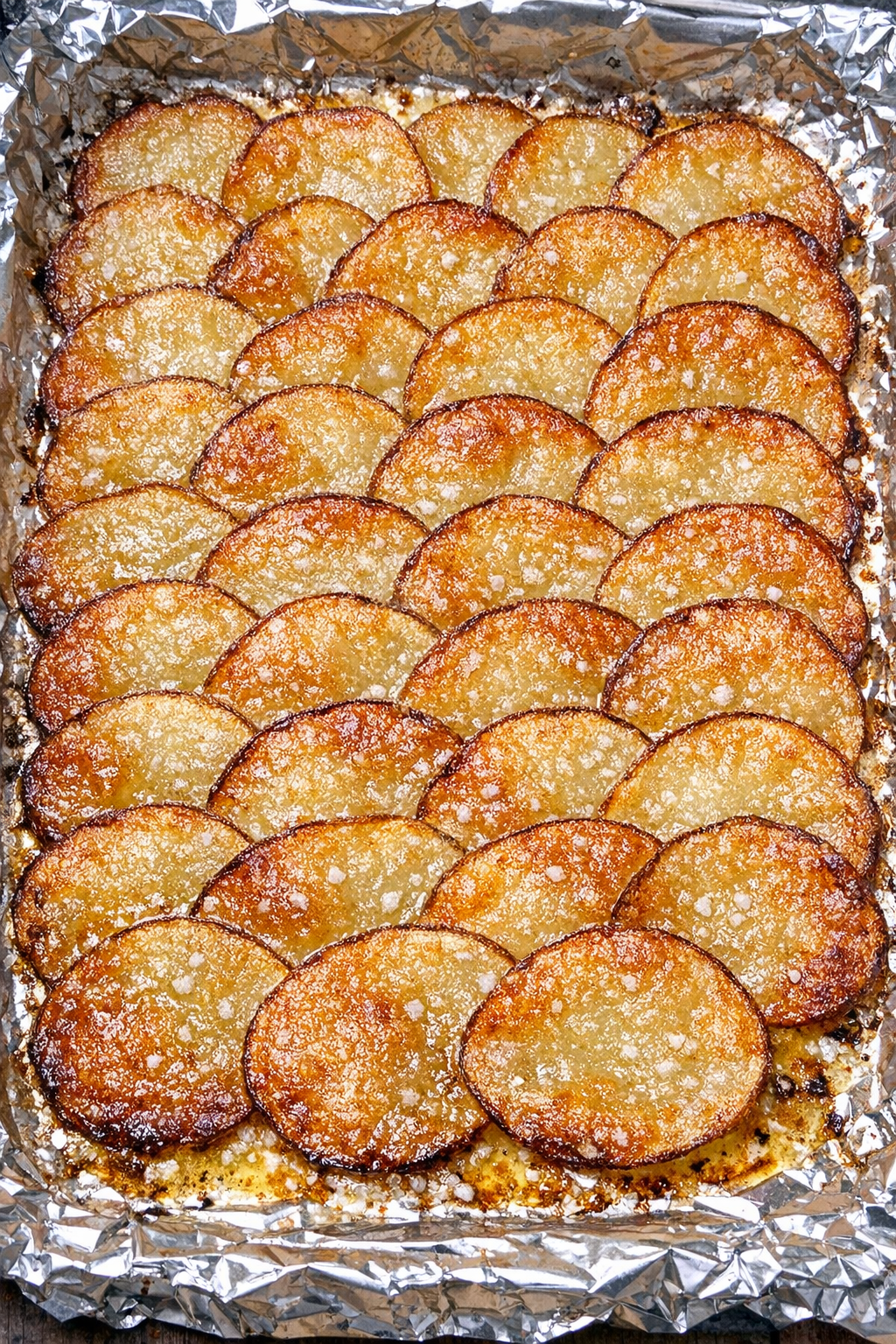 Golden buttery potato tile crisps on a foil-lined baking sheet