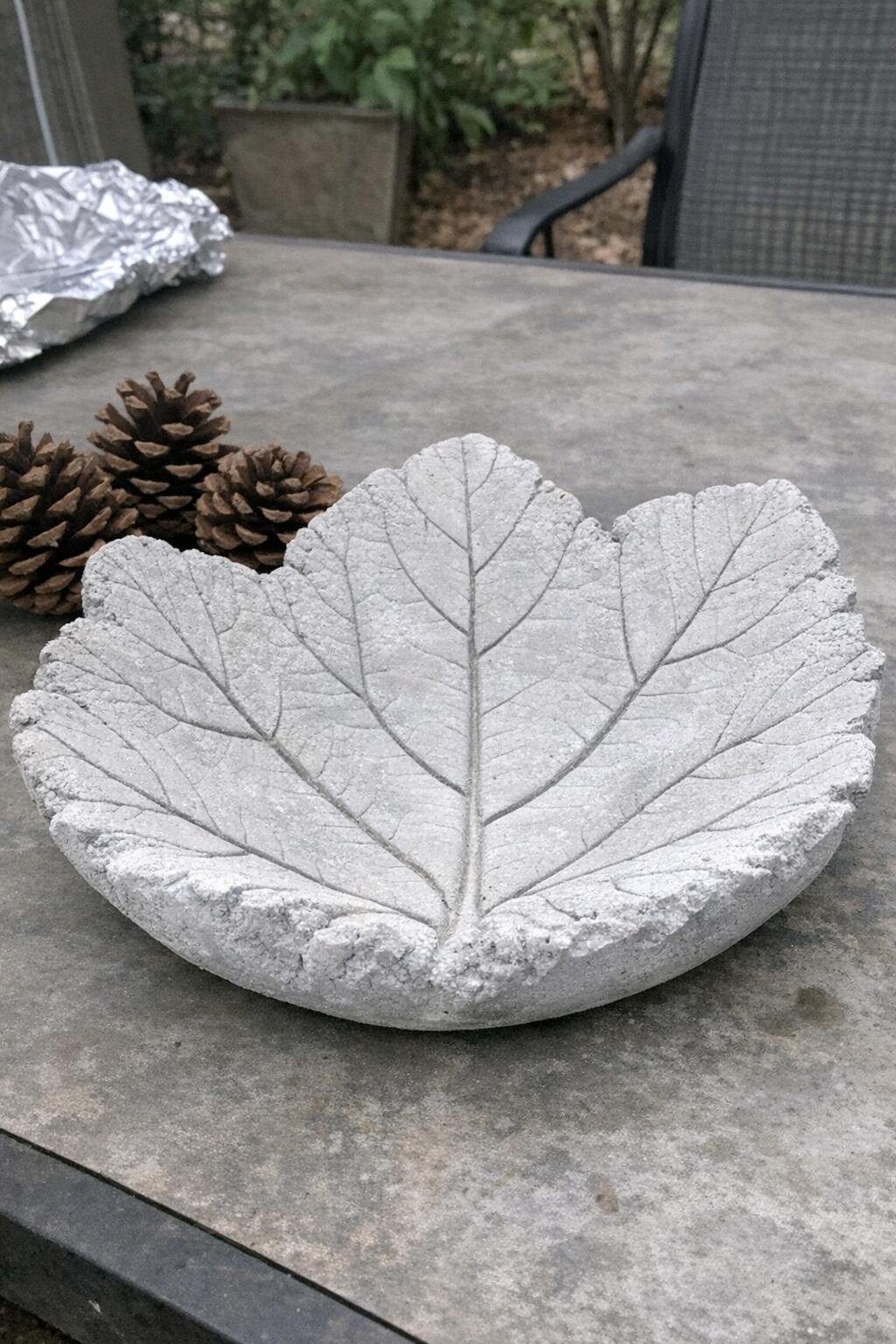 White-frosted concrete leaf bowl on an outdoor table