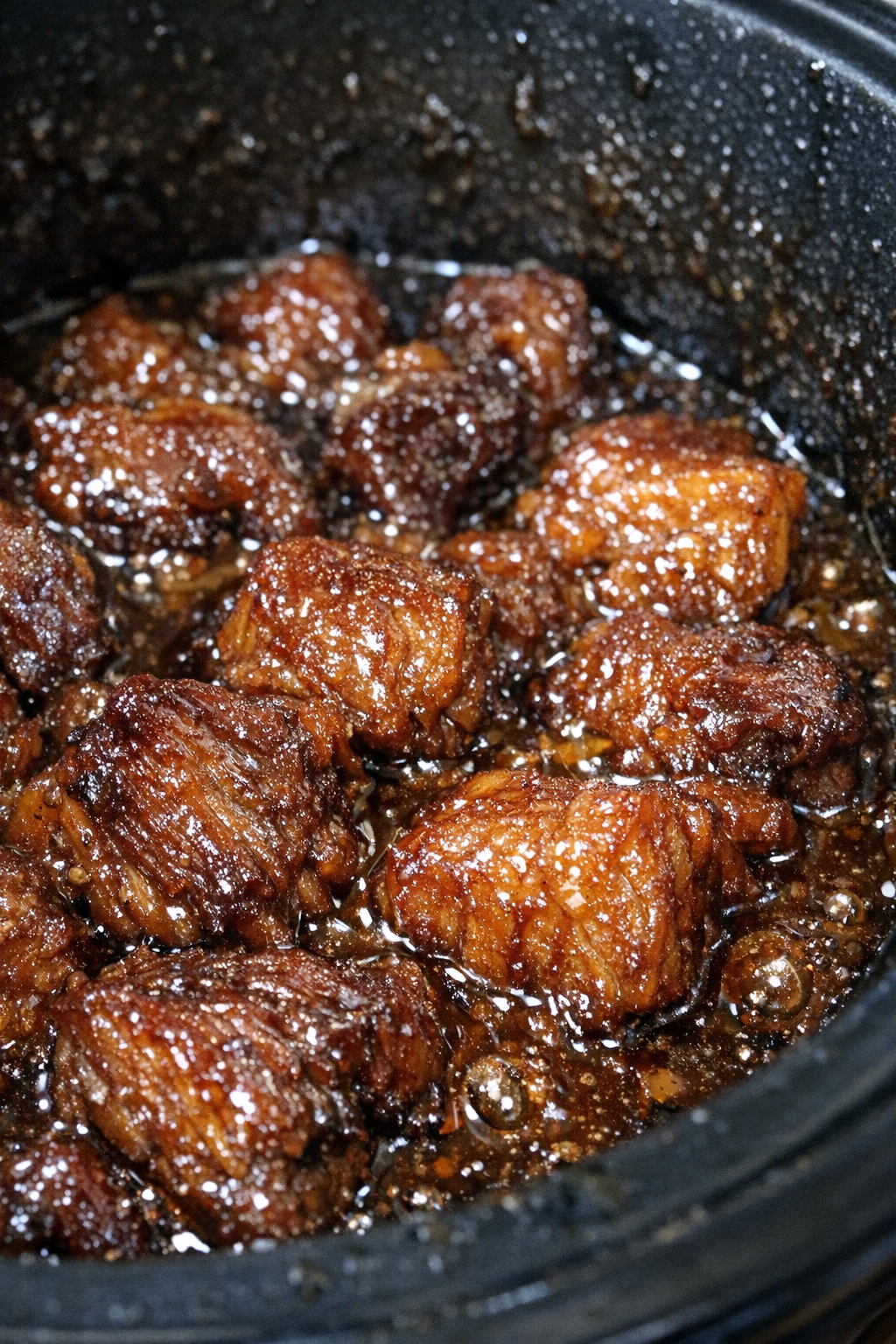 Slow cooker gelatinous protein chunks in glossy amber sauce