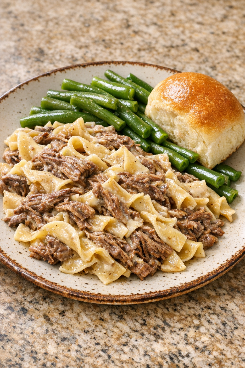 Final plated creamy beef pasta served in a bowl with simple sides