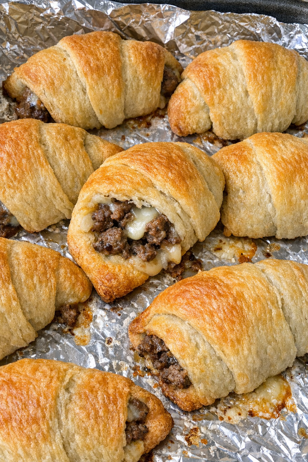 Oven baked 4-ingredient beef crescent bites on a foil-lined baking sheet