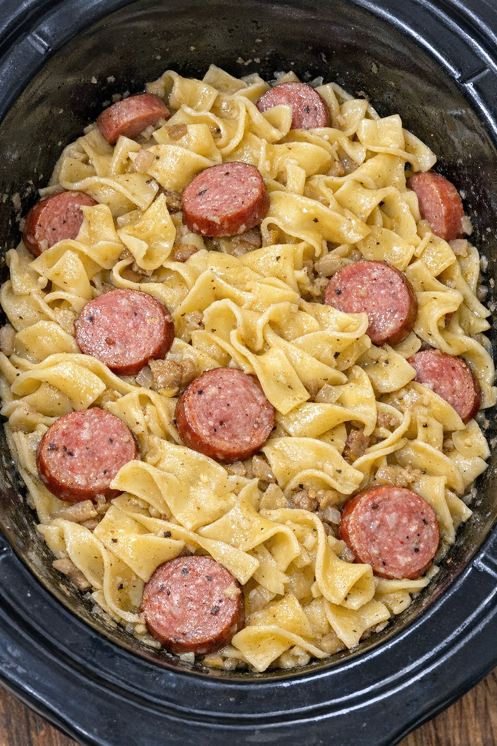 Slow cooker Amish summer sausage noodles in a black slow cooker