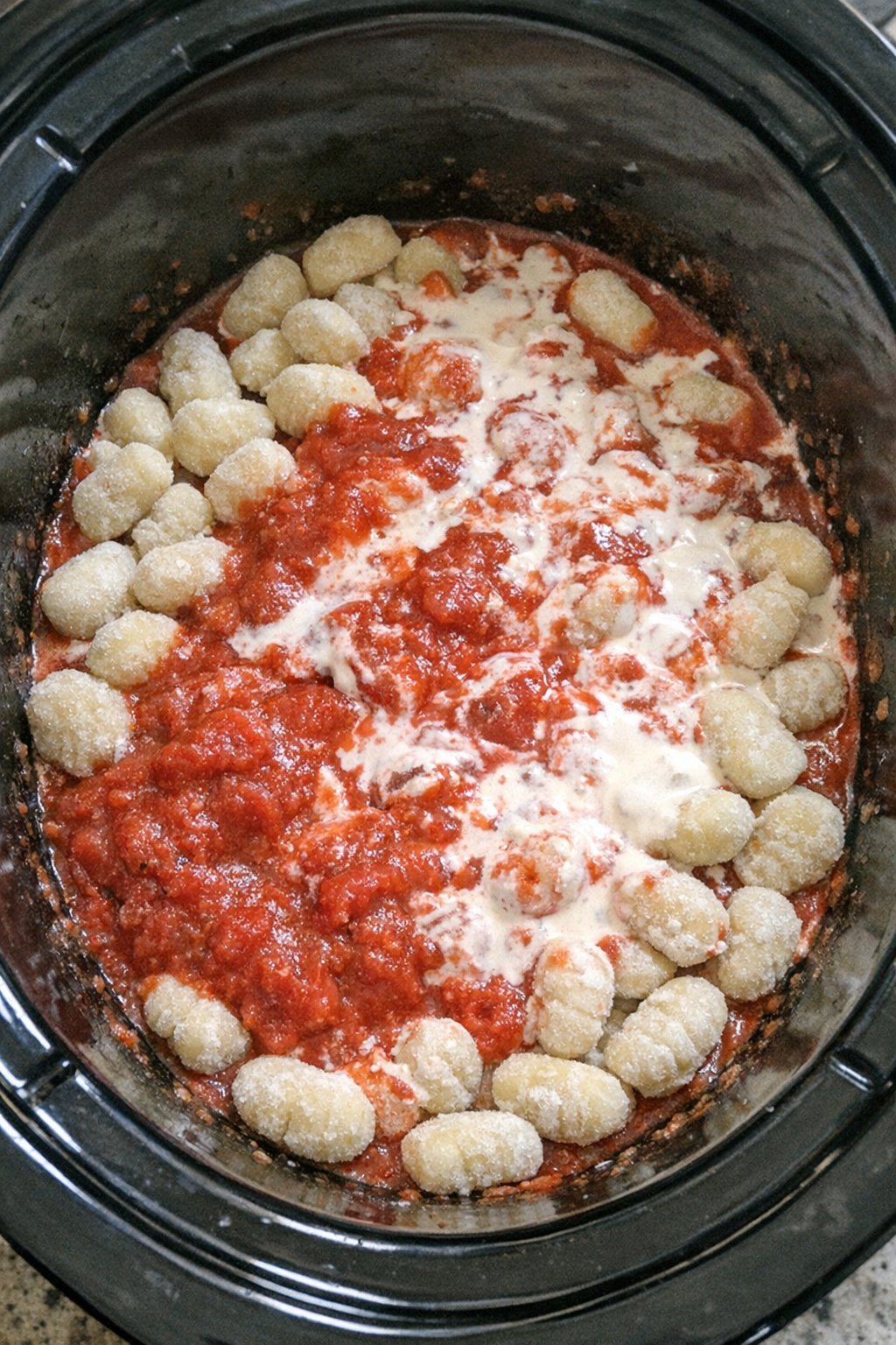 Gnocchi mixed with sauce and cream in slow cooker