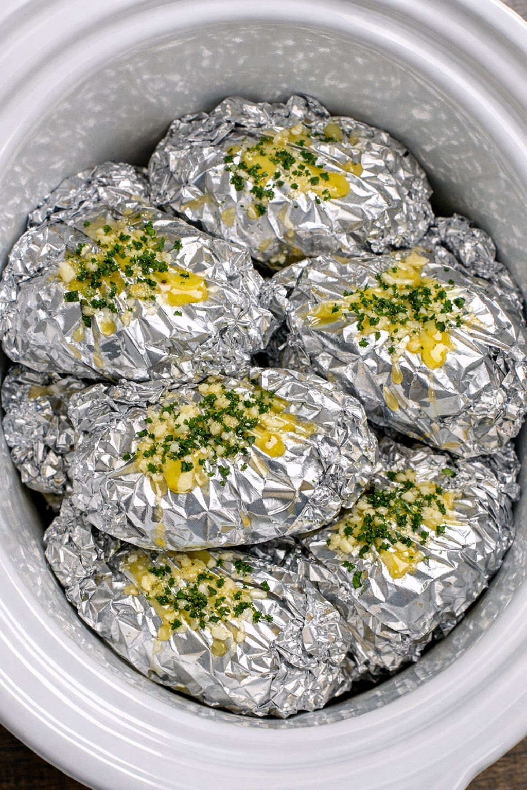 Slow cooker cheesy rigatoni foil packets in a white slow cooker