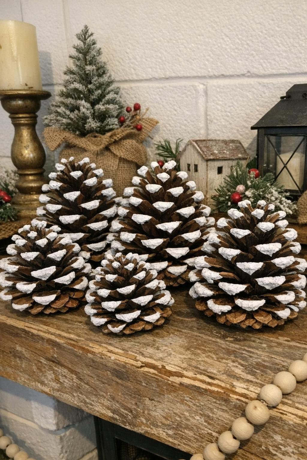 Snow-tipped pine cones arranged on a mantel