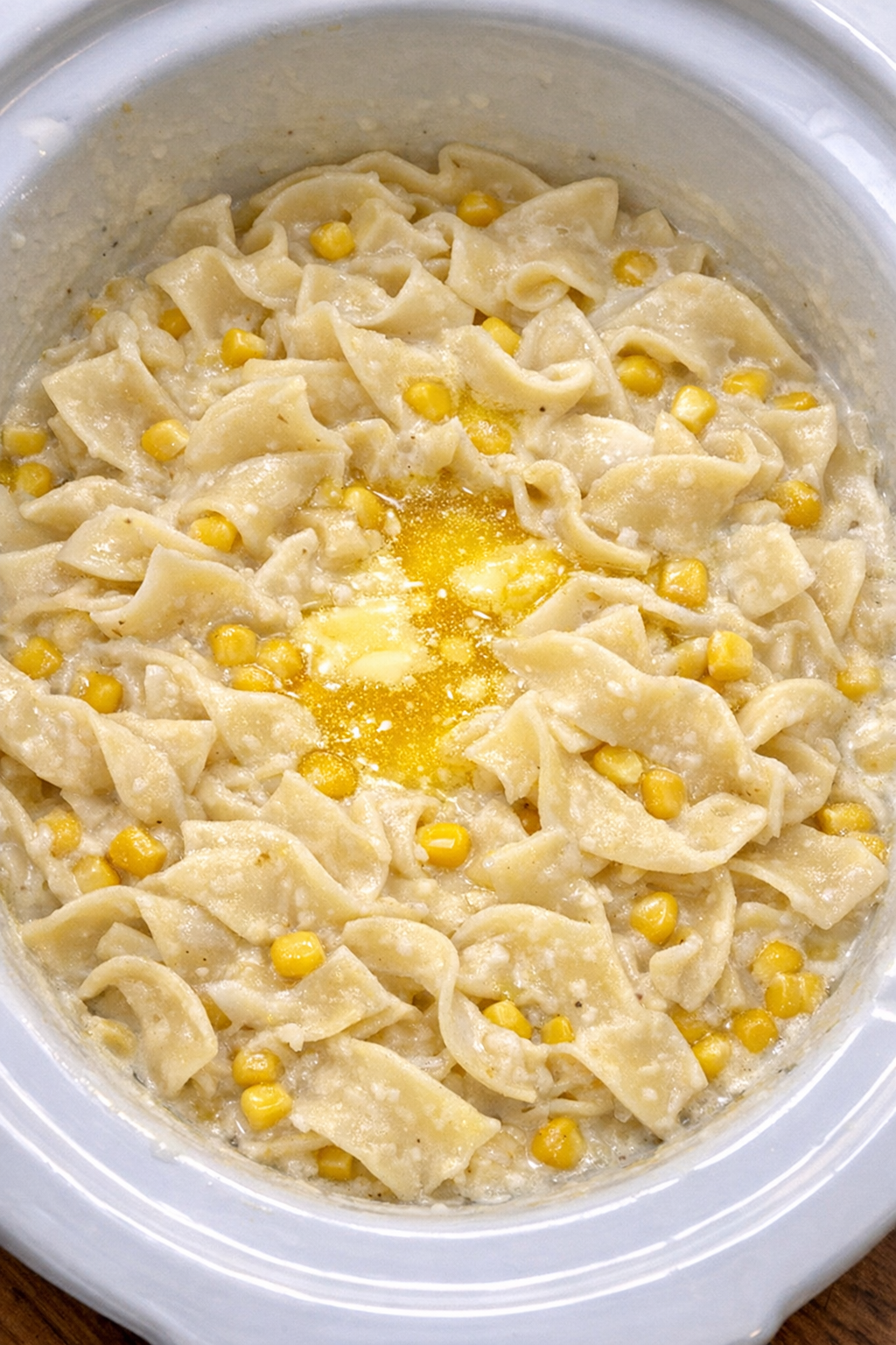 Slow cooker Amish corn cream noodles in a white slow cooker