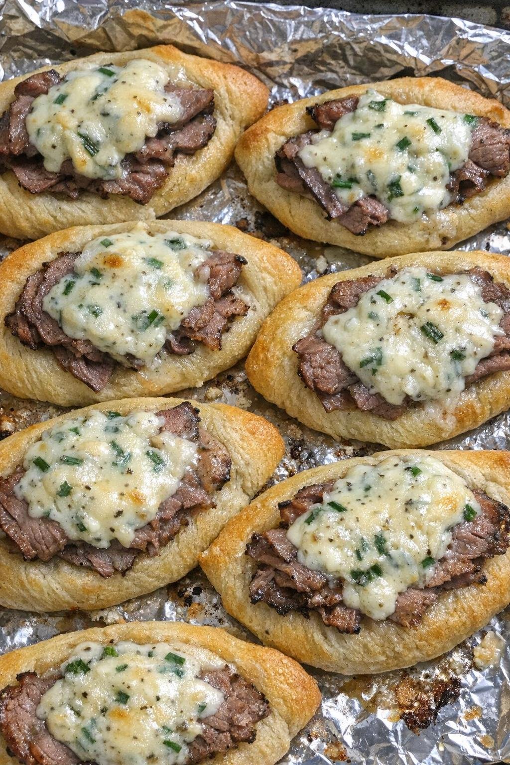 Golden brown crescent dough boats filled with roast beef and chive cream cheese