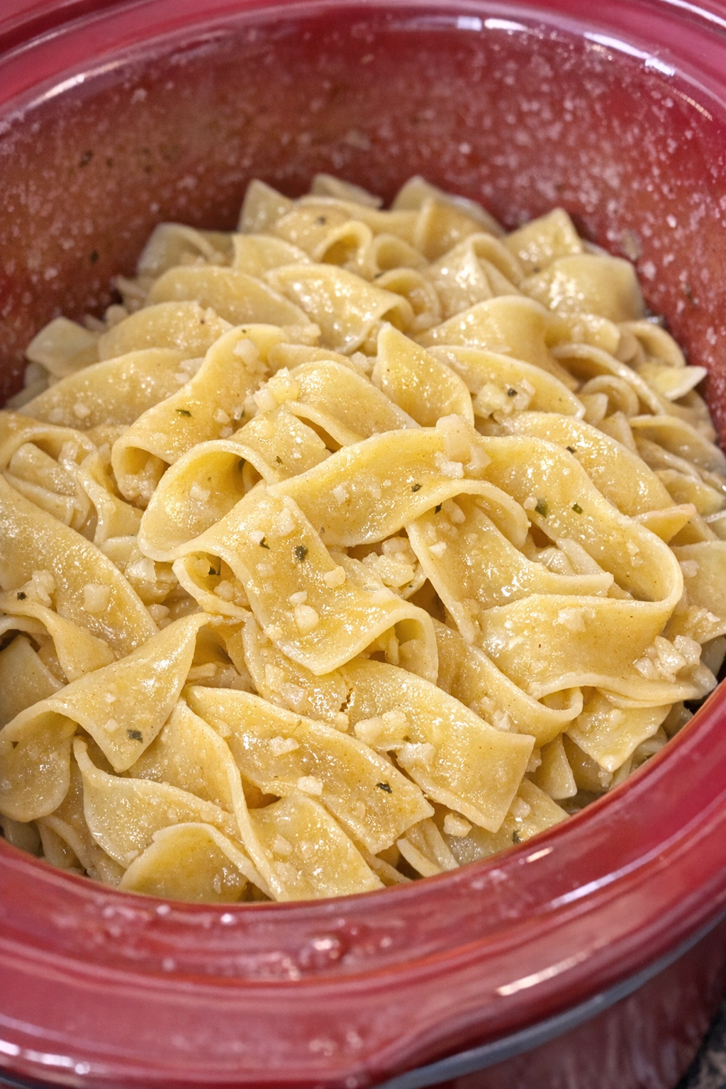 Slow cooker Amish garlic noodles in a red slow cooker