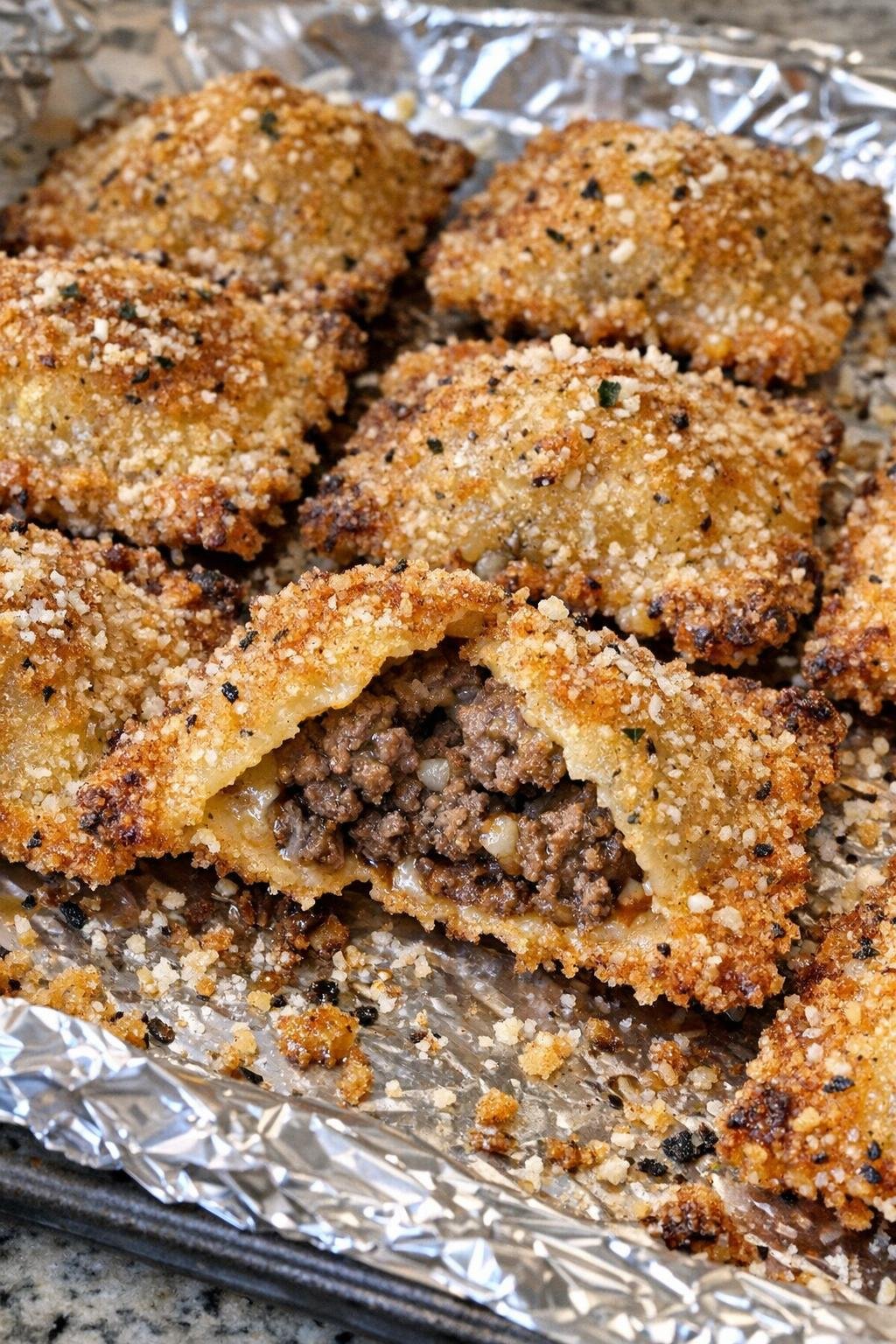 Oven baked beef ravioli bites on a foil-lined baking sheet