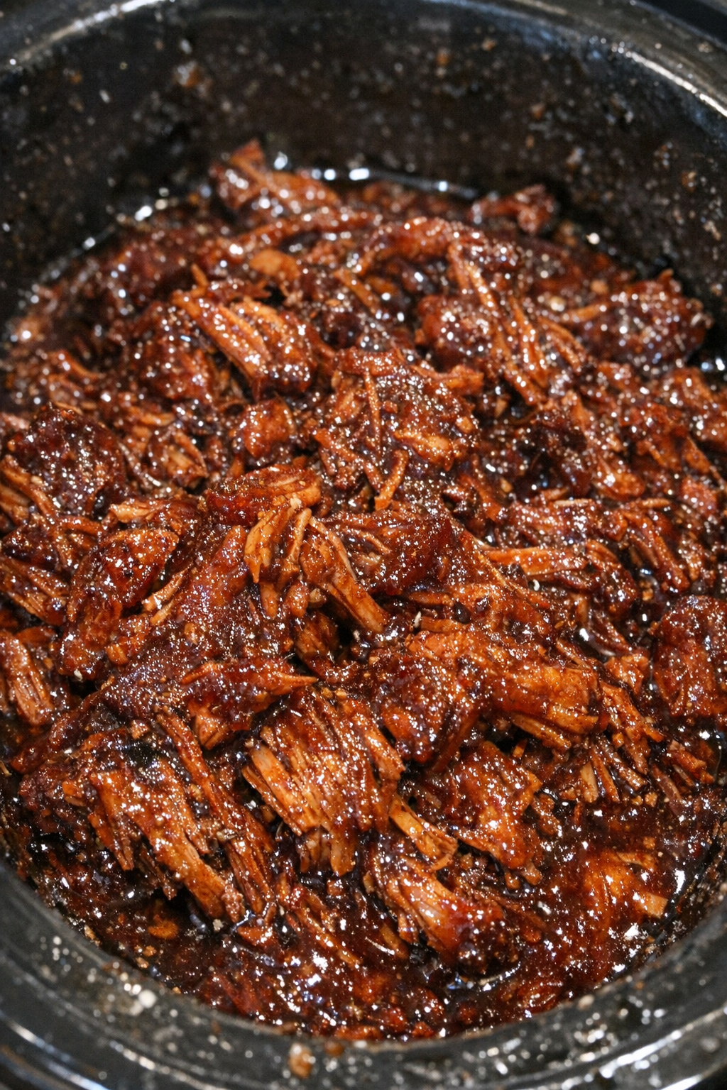 Slow cooker shredded protein in dark crimson glaze