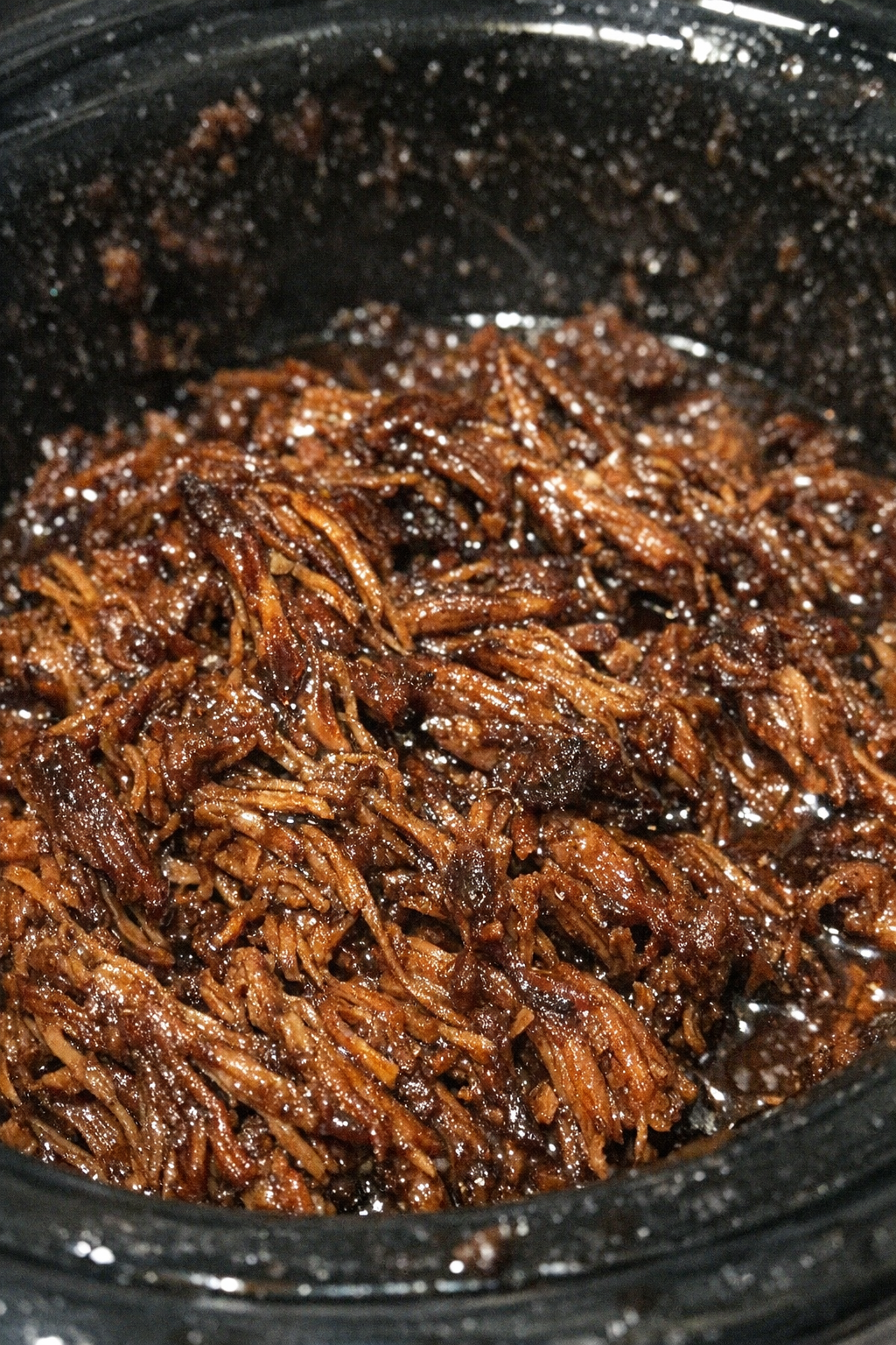 Finished caramelized shredded protein in a slow cooker