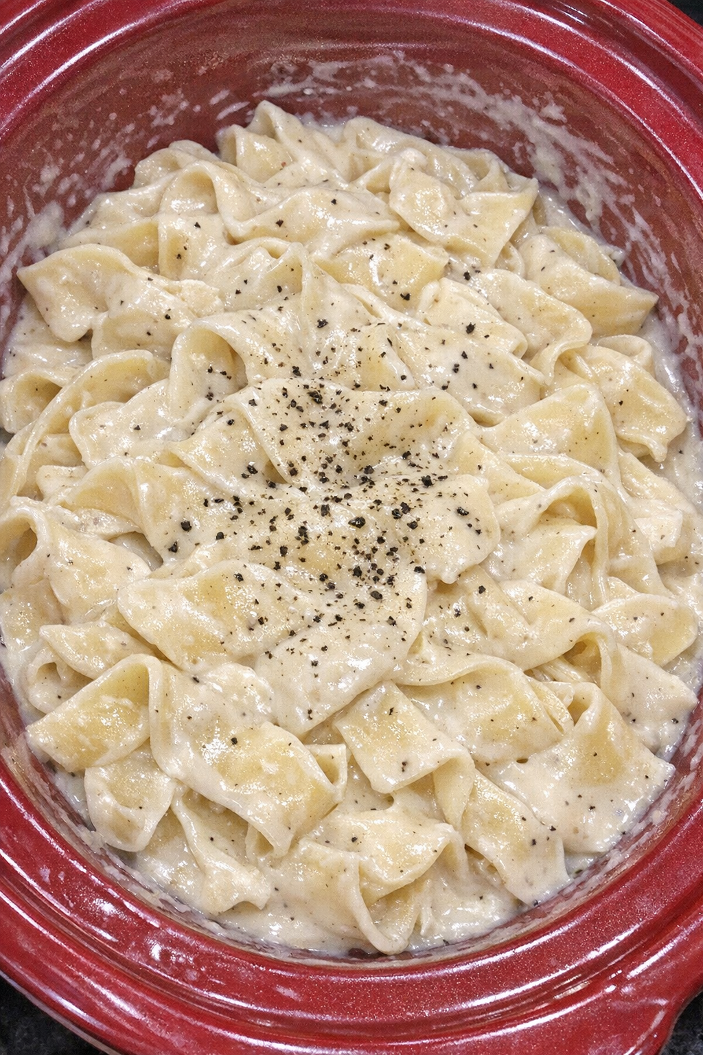 Slow cooker Amish cream cheese noodles in a red slow cooker