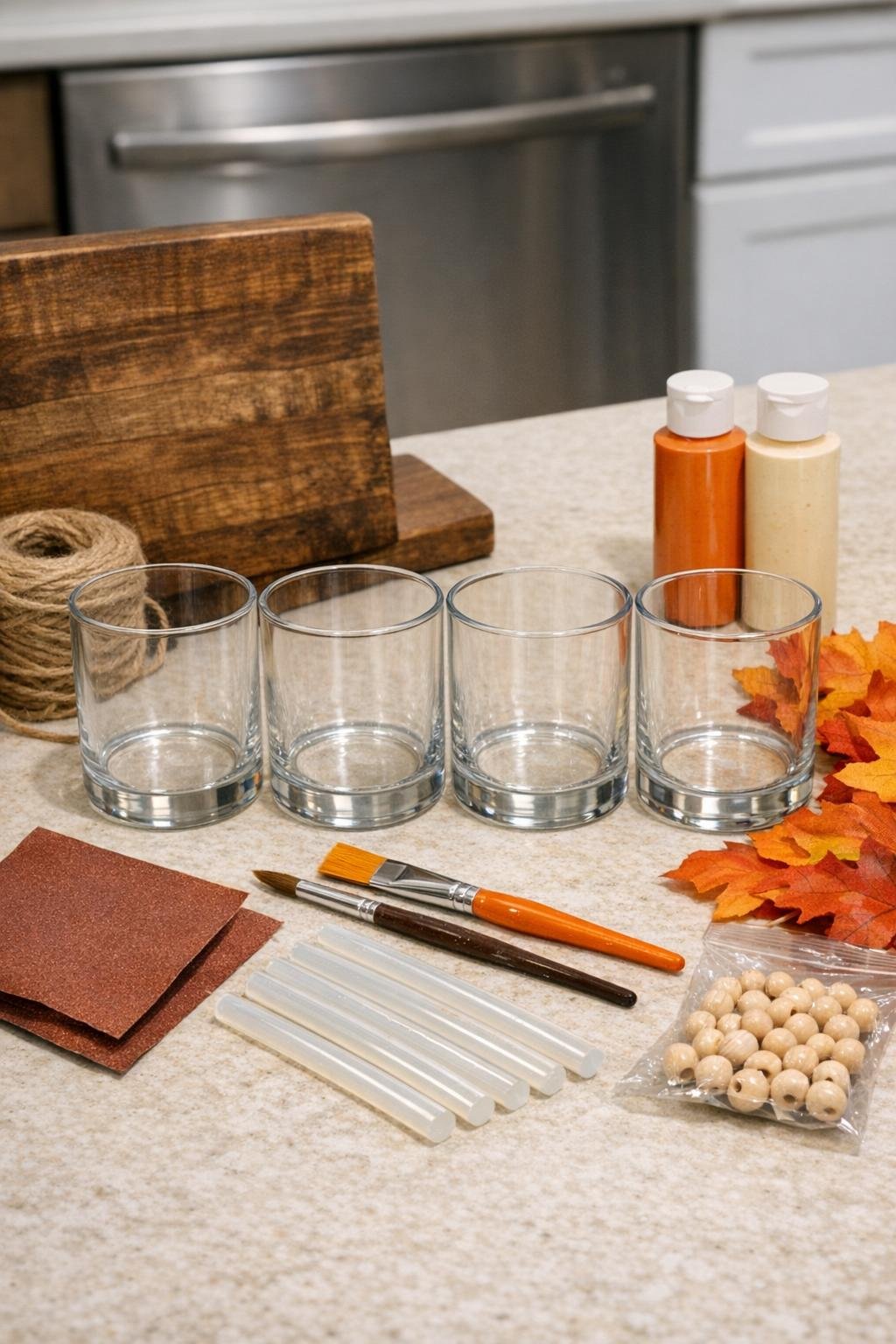 Materials laid out for a glass candle jar kitchen organizer