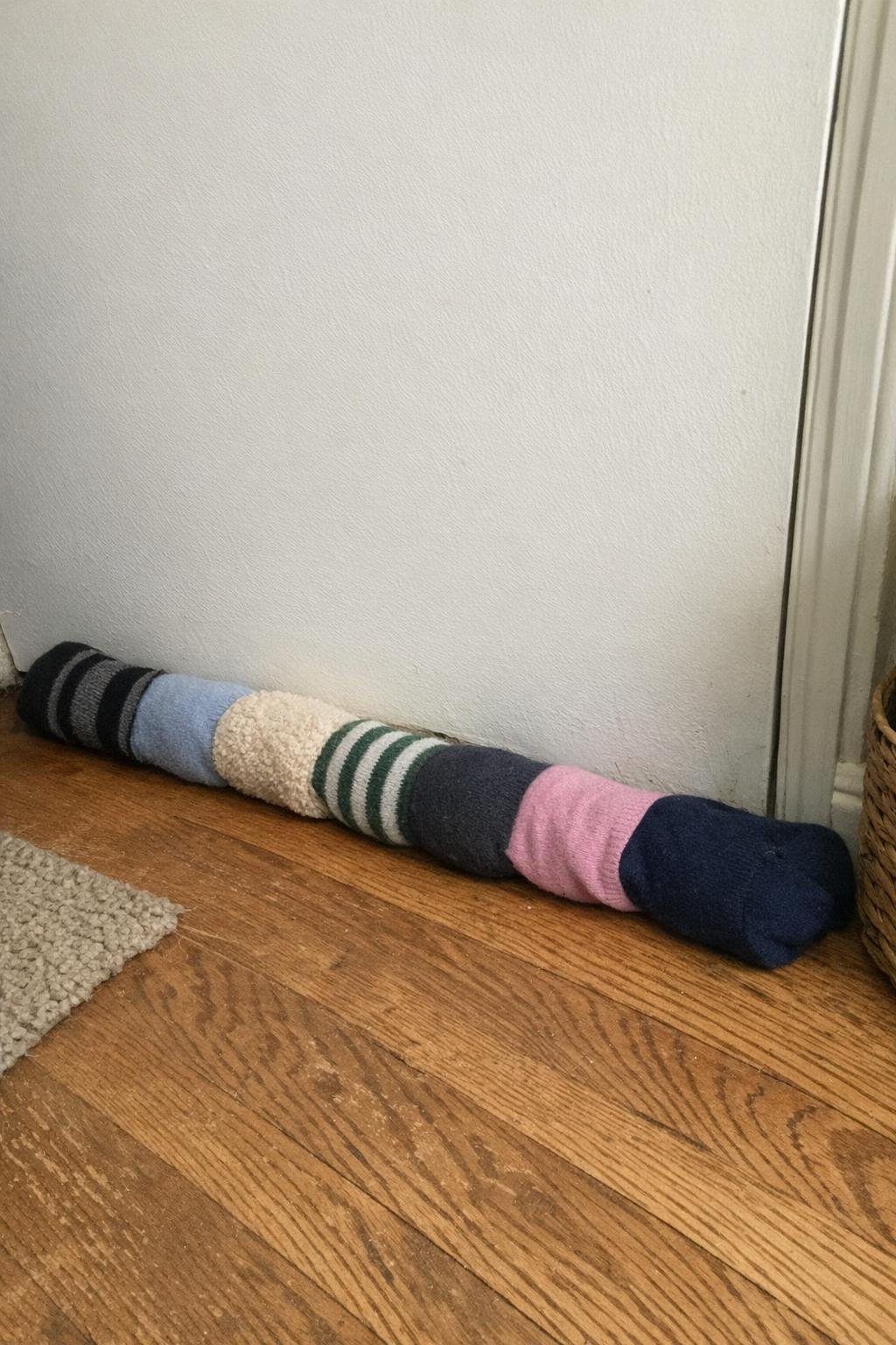 A long sock draft stopper resting along the bottom of a door
