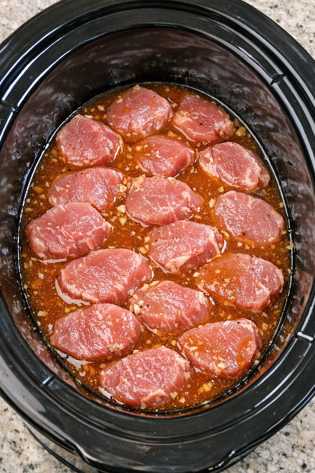 Pork medallions in slow cooker covered with amber sauce