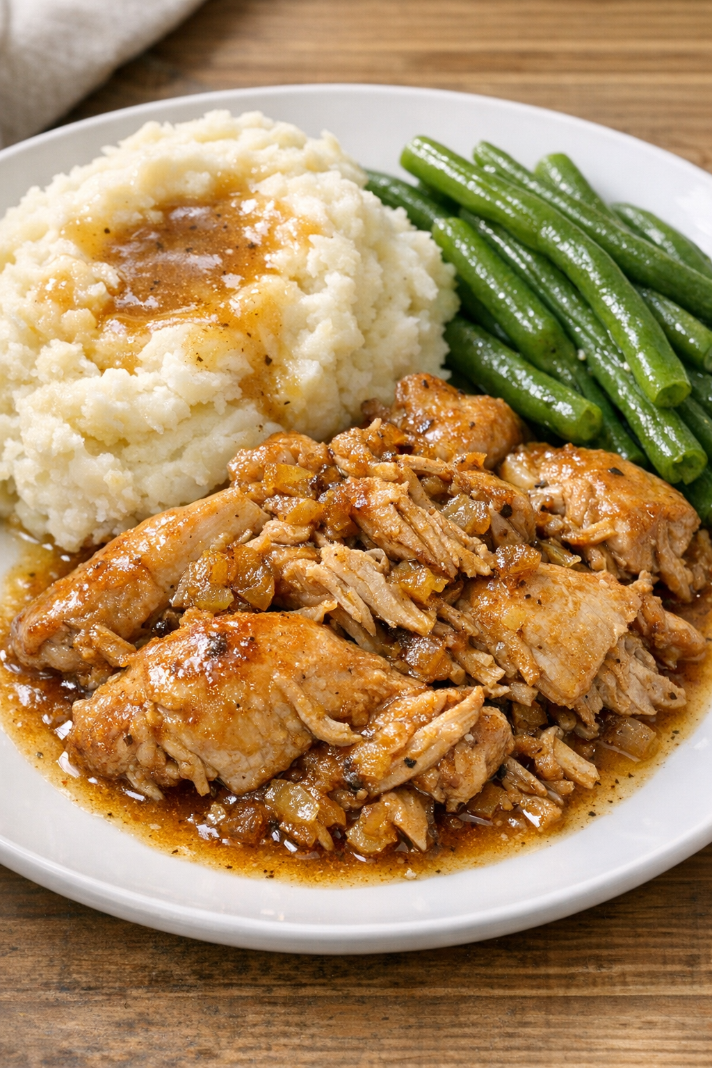 Finished slow cooker chicken plated with sauce