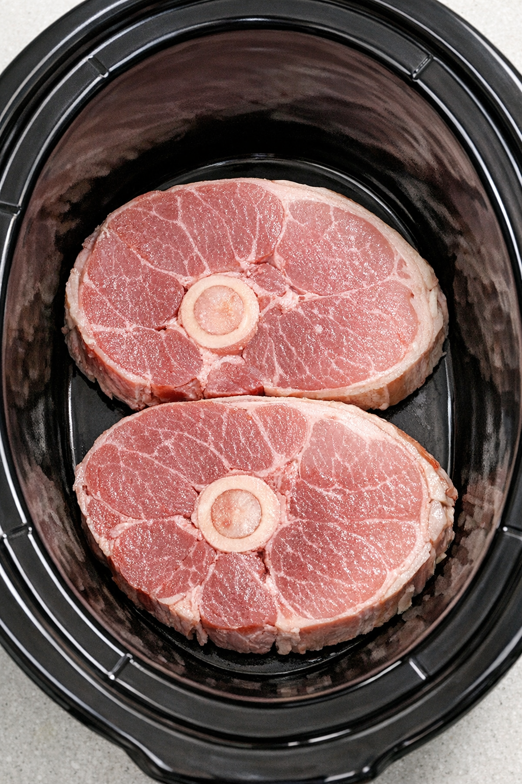 Ham steaks arranged in the slow cooker