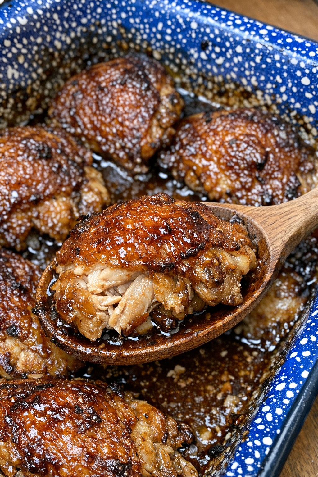 Caramelized baked chicken in a blue speckled baking dish