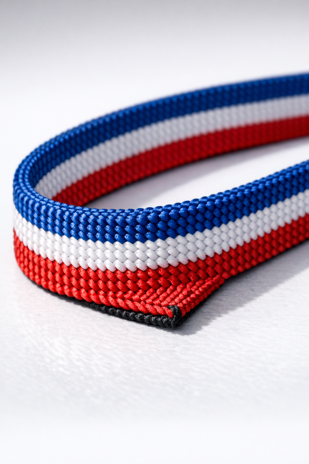 Finished heavy-duty strapping made from fused red, white, and blue nylon shoelaces