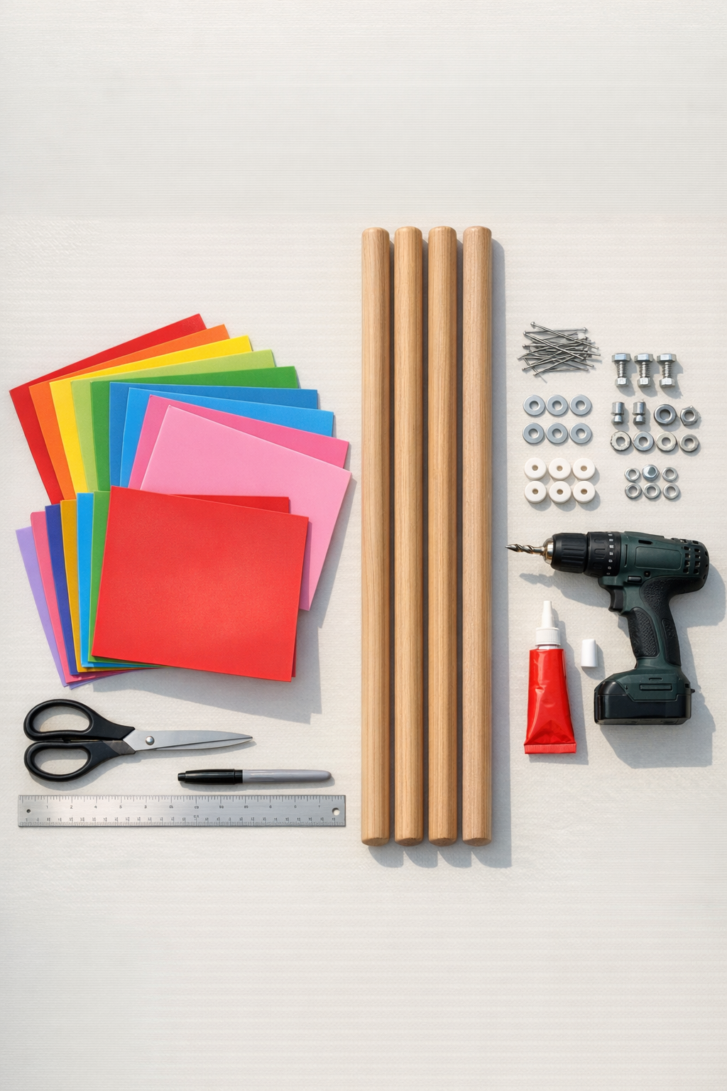 Colorful plastic placemats, broom handles, pins, beads, and basic tools laid out on a table