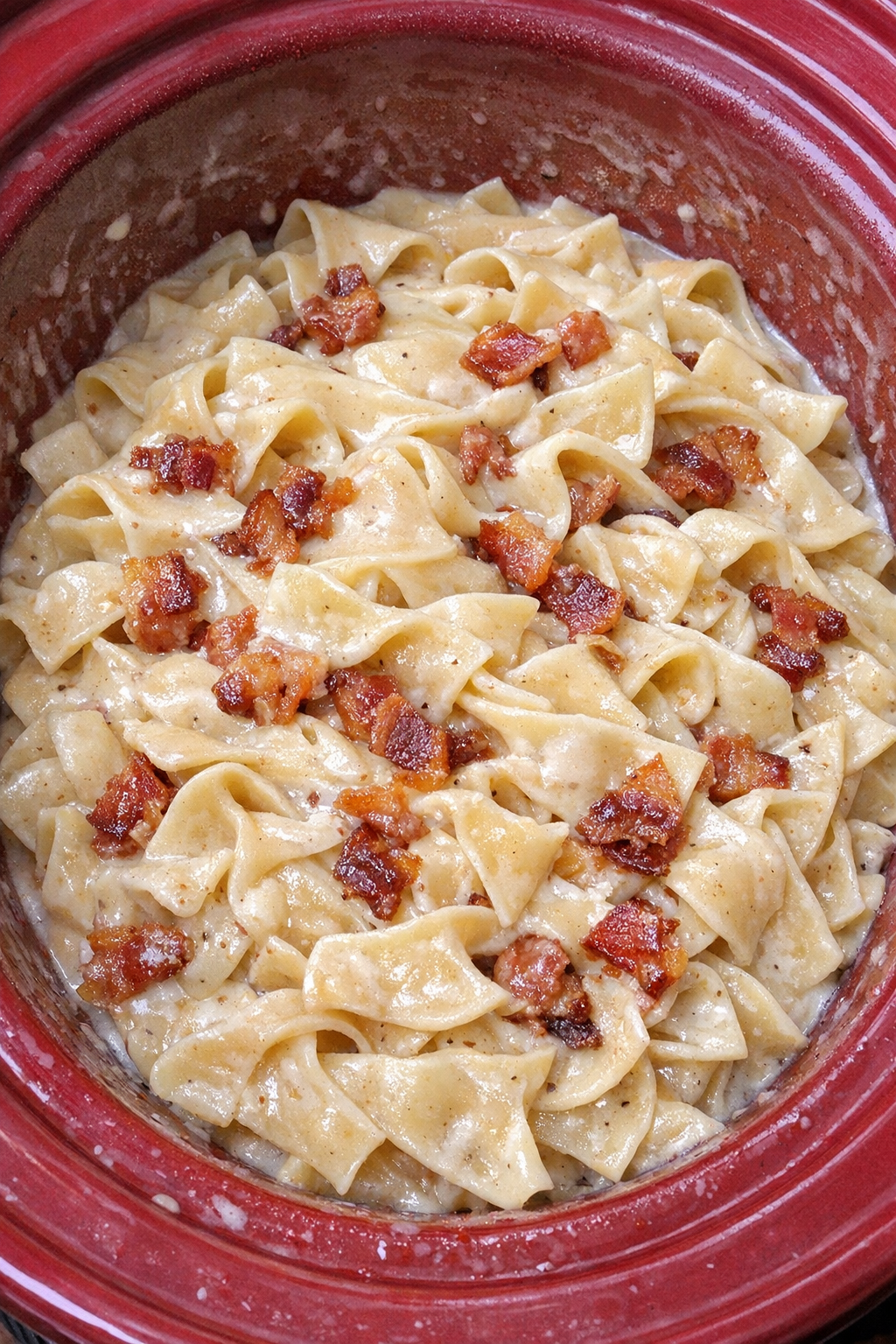 Slow cooker Amish bacon cream noodles in a red slow cooker