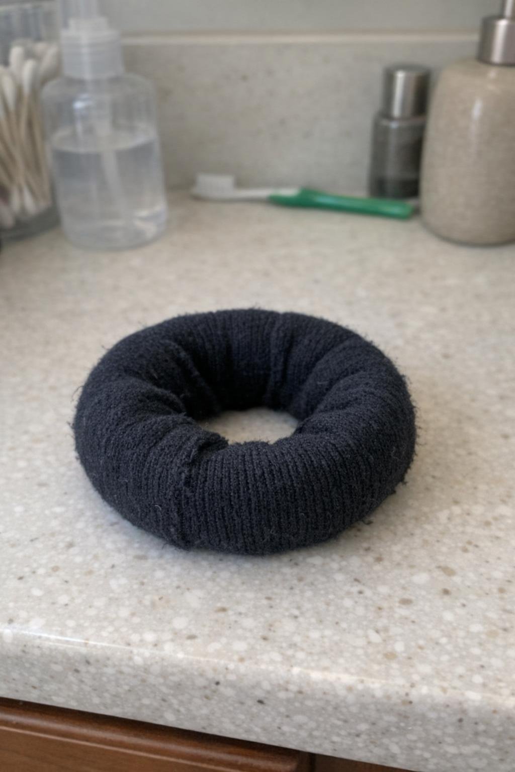 A rolled sock hair donut resting on a bathroom counter