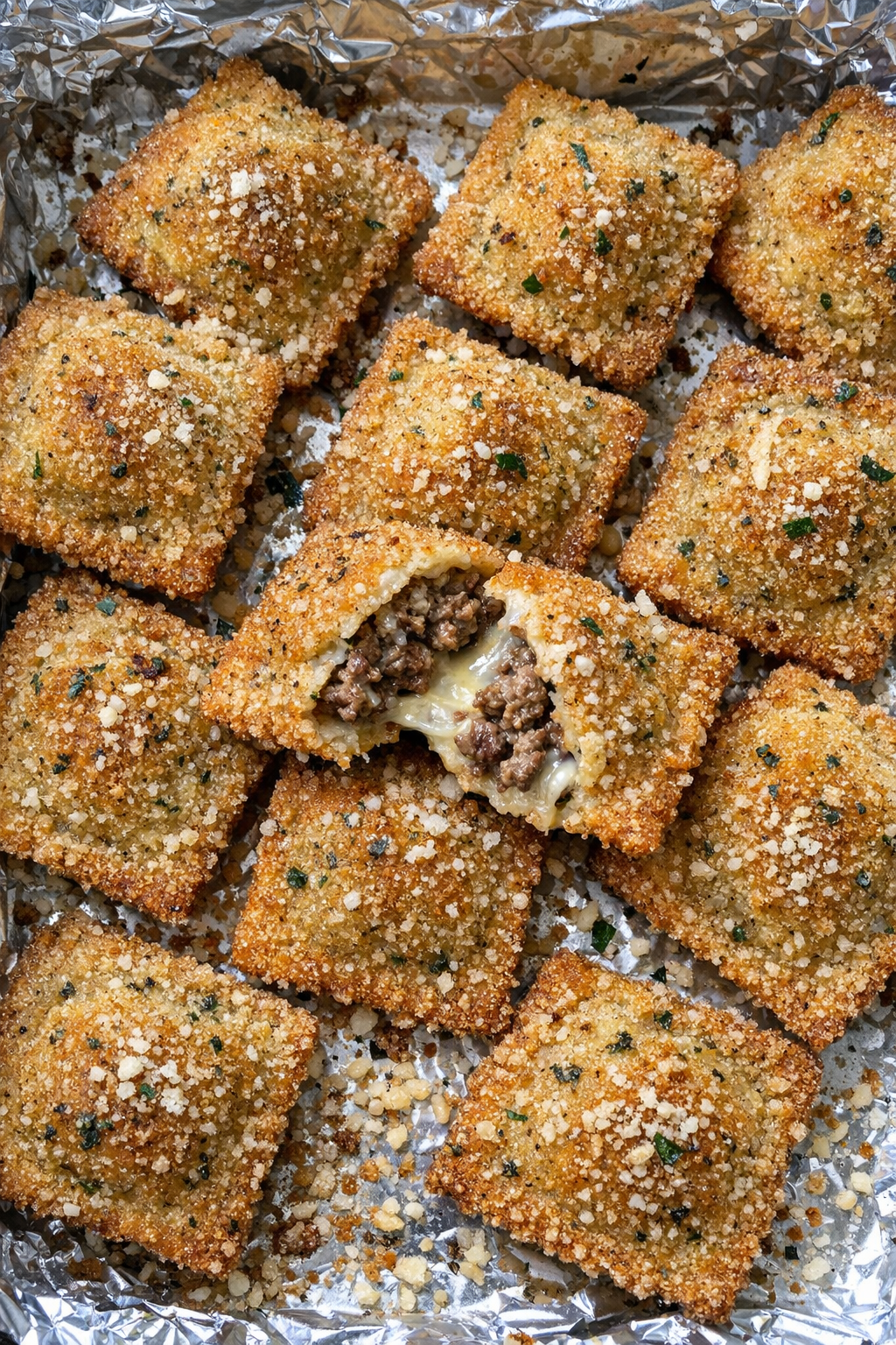 Oven baked beef toasted ravioli on a foil-lined baking sheet