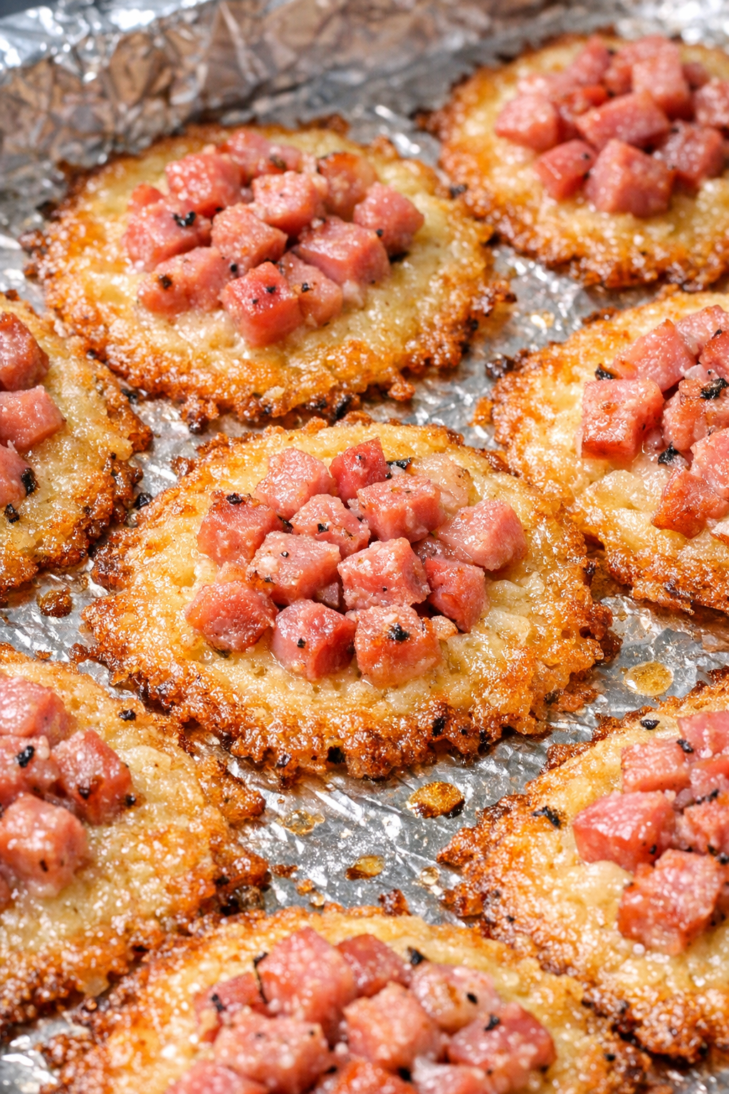 Low carb ham cheese crisps on a foil-lined baking tray