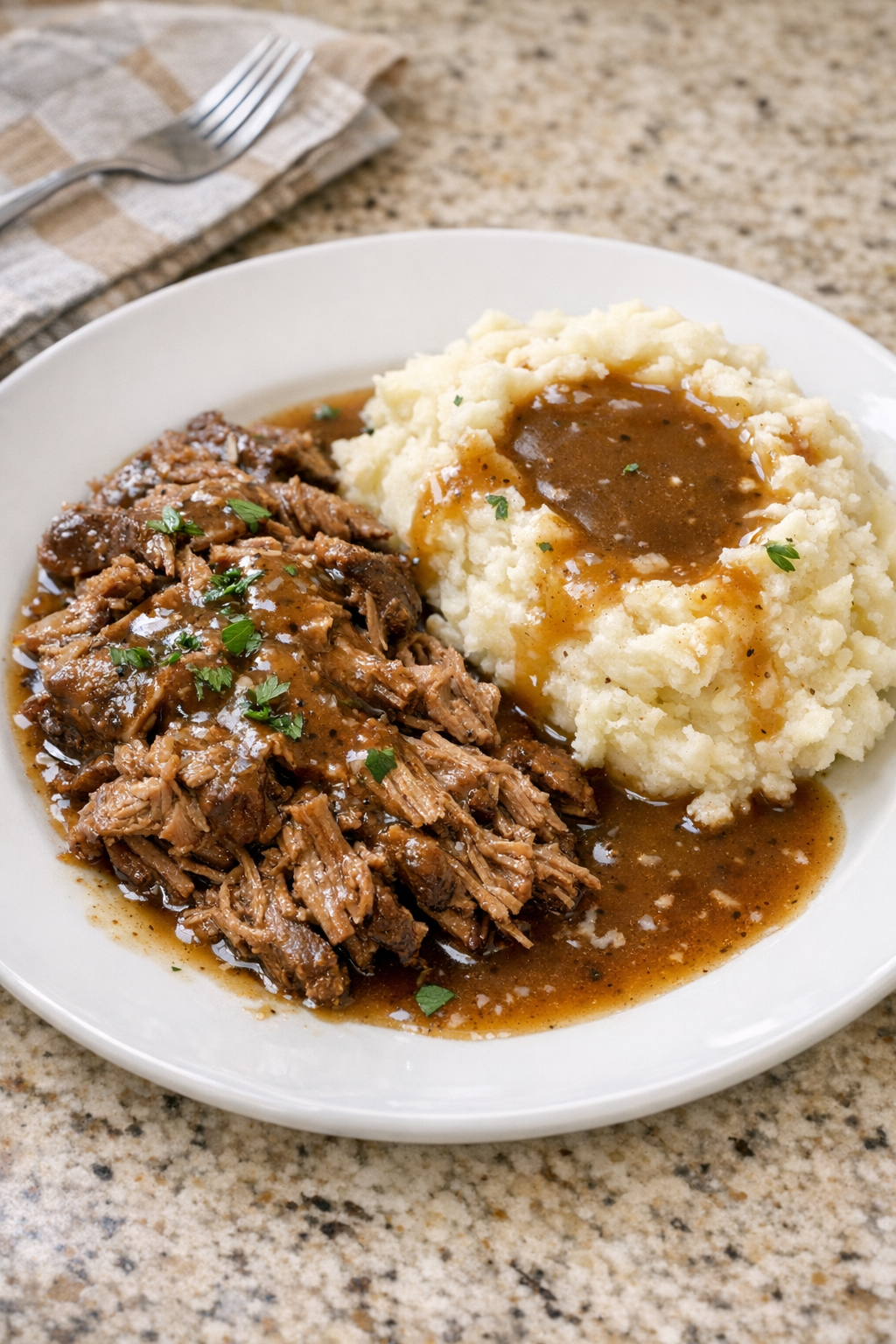 Finished Amish brown gravy beef plated with mashed potatoes
