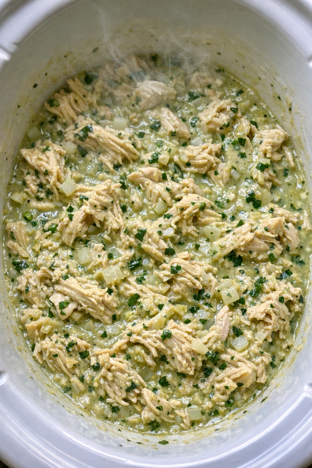 Slow cooker creamy avocado salsa chicken in a white slow cooker