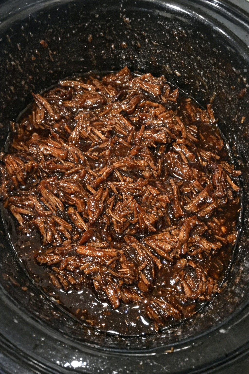 Slow cooker shredded beef in dark amber glaze