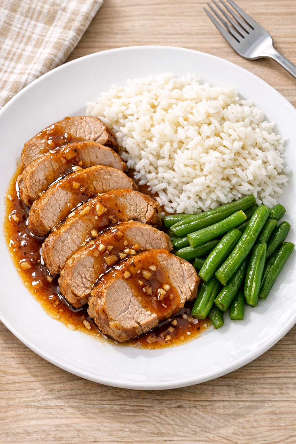 Finished slow cooker pork tenderloin plated with sauce