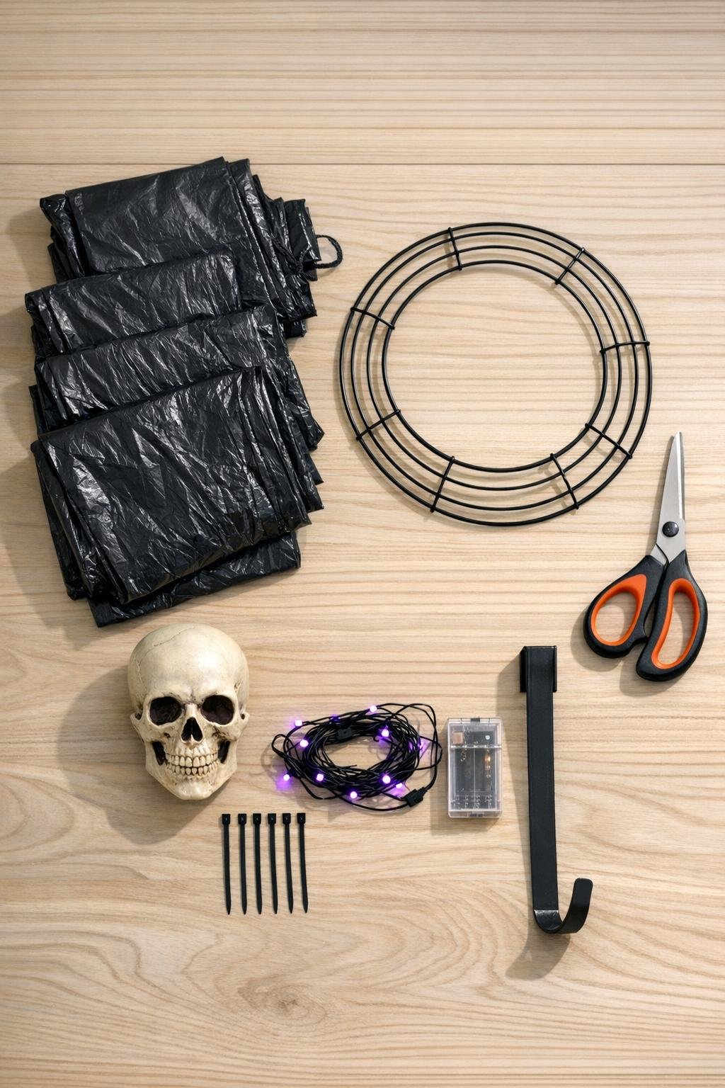 Materials for a black fringe wreath laid out on a table