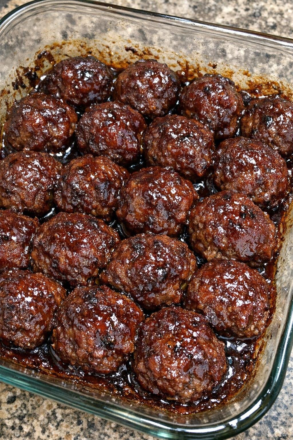 Sticky glazed beef meatballs in a glass baking dish