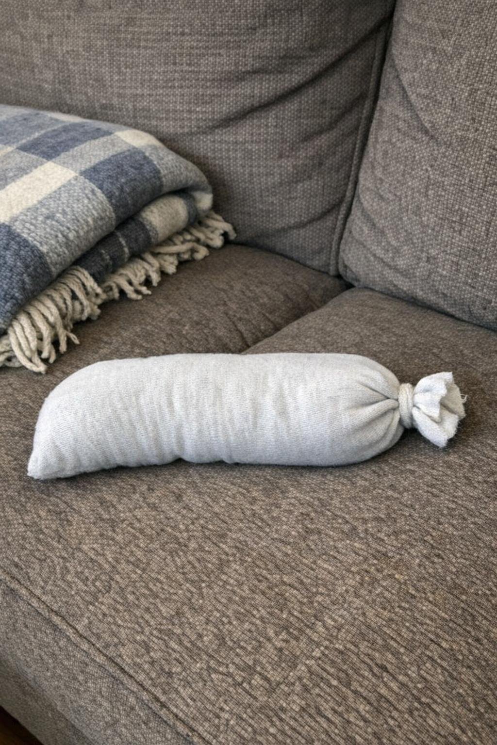 A tube sock turned into a rice heating pad on a couch
