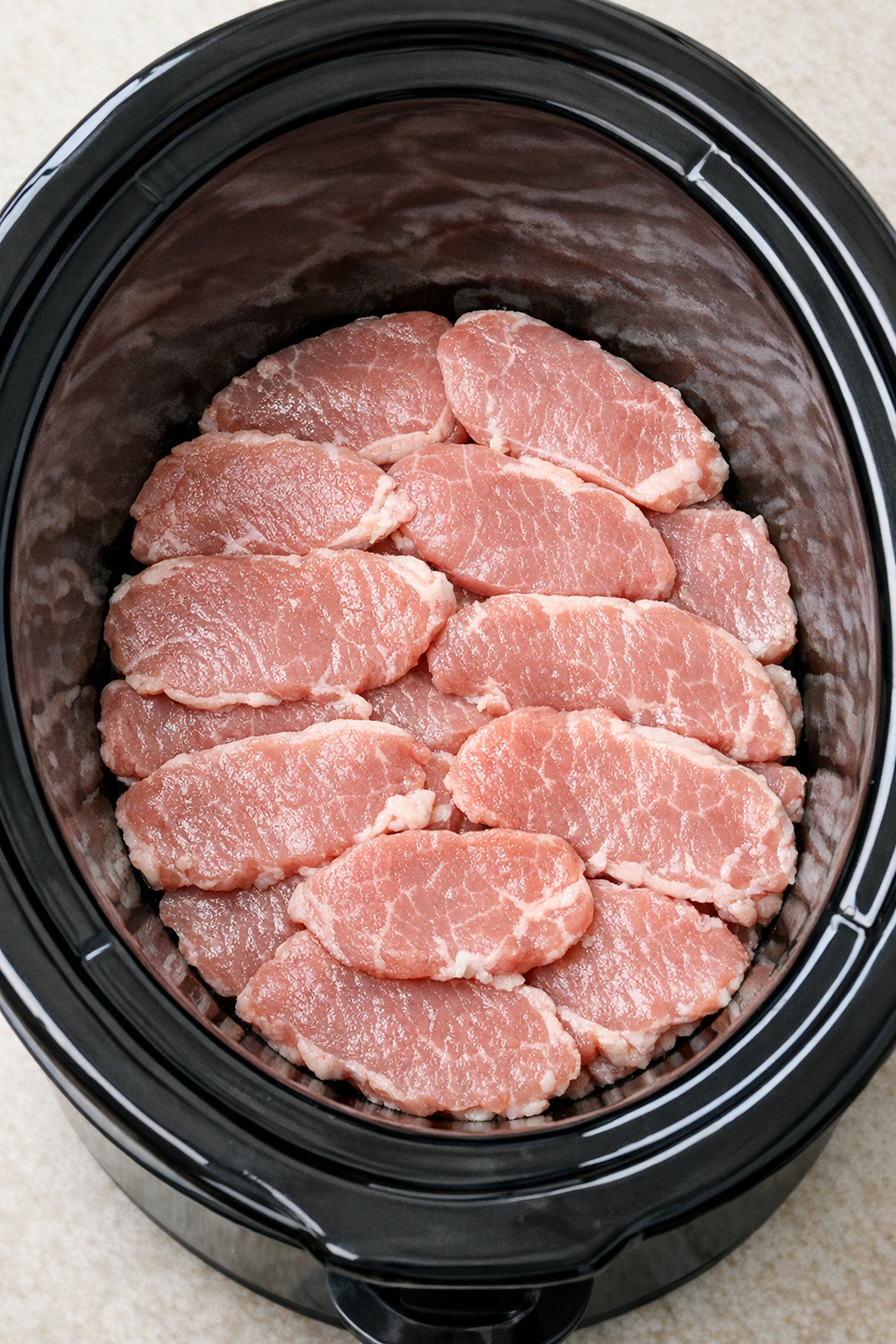 Pork cutlets arranged in the slow cooker