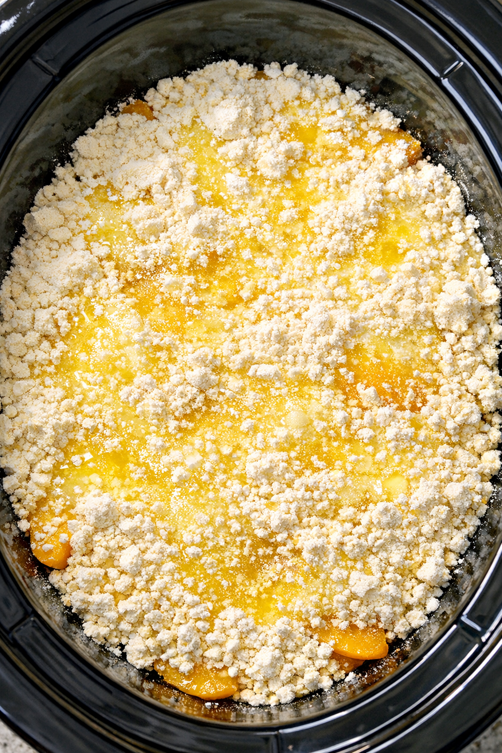 Dry cake mix layered over peaches with melted butter drizzled on top