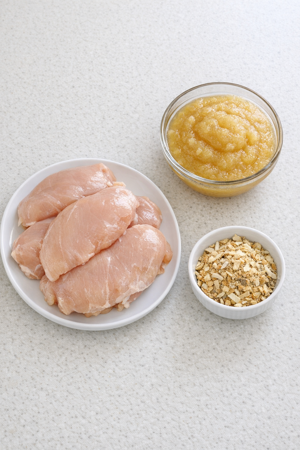 Chicken, applesauce, and onion soup mix ingredients arranged on a counter