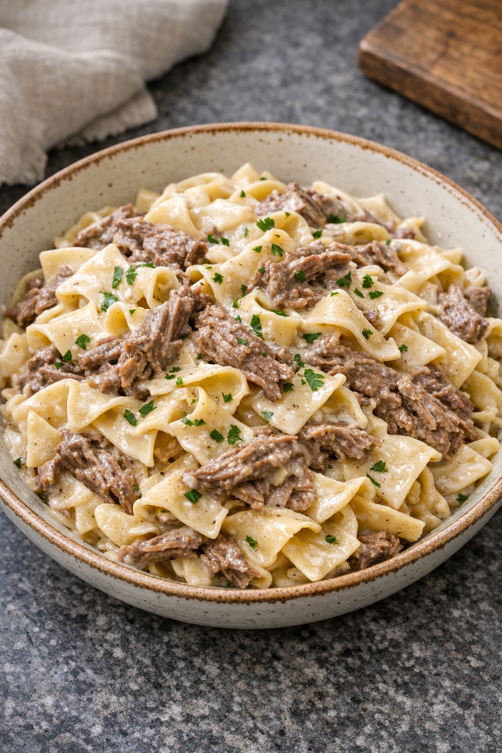 Finished creamy beef pasta plated in a rustic bowl