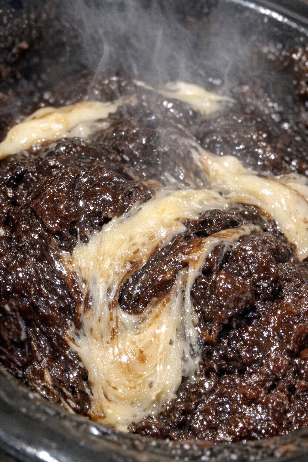 Slow cooker dessert with glossy dark mahogany swirls and pale nougat ribbons