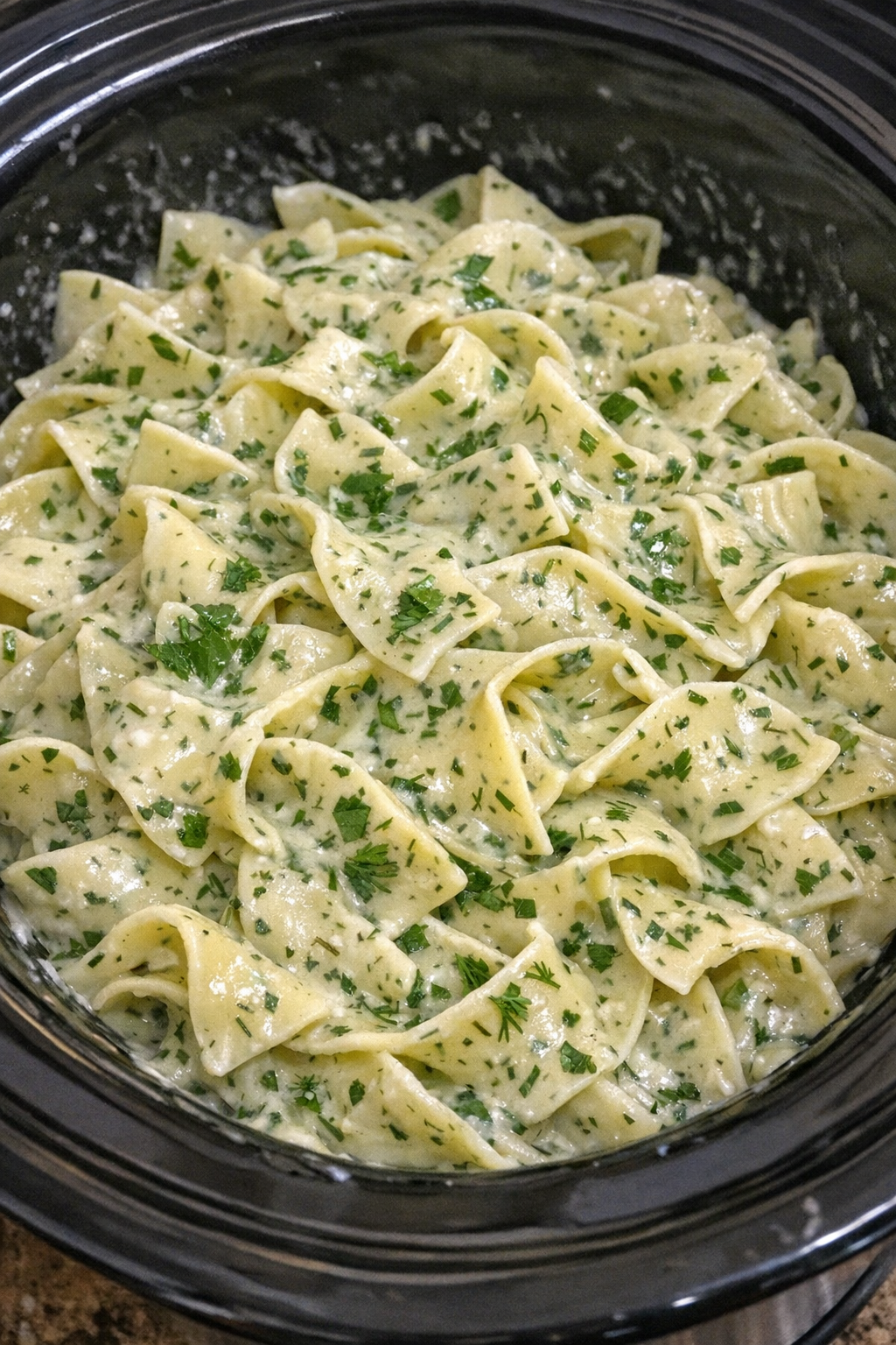 Finished Amish summer herb cream noodles in a black slow cooker