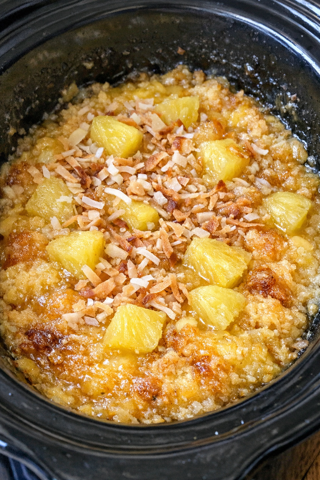 Slow cooker painkiller dump cake in a black slow cooker