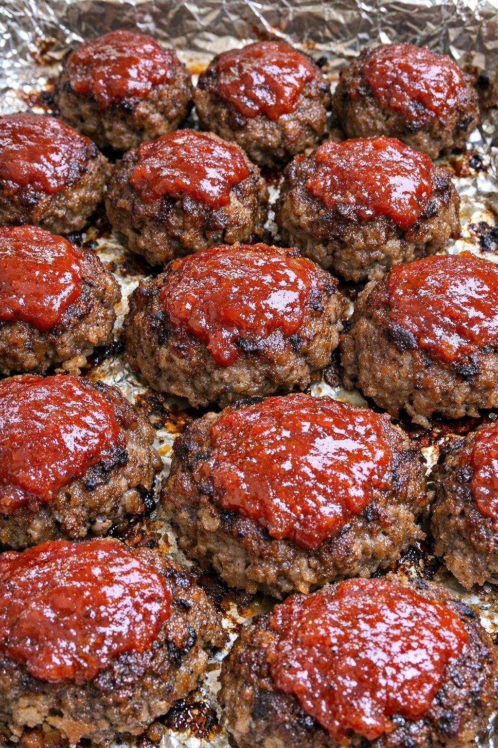 Oven baked 3-ingredient beef meatloaf bites on a foil-lined baking sheet