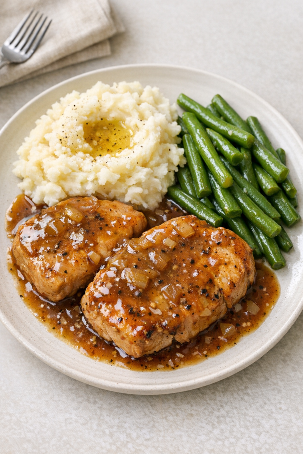Finished slow cooker boneless pork chops plated with gravy
