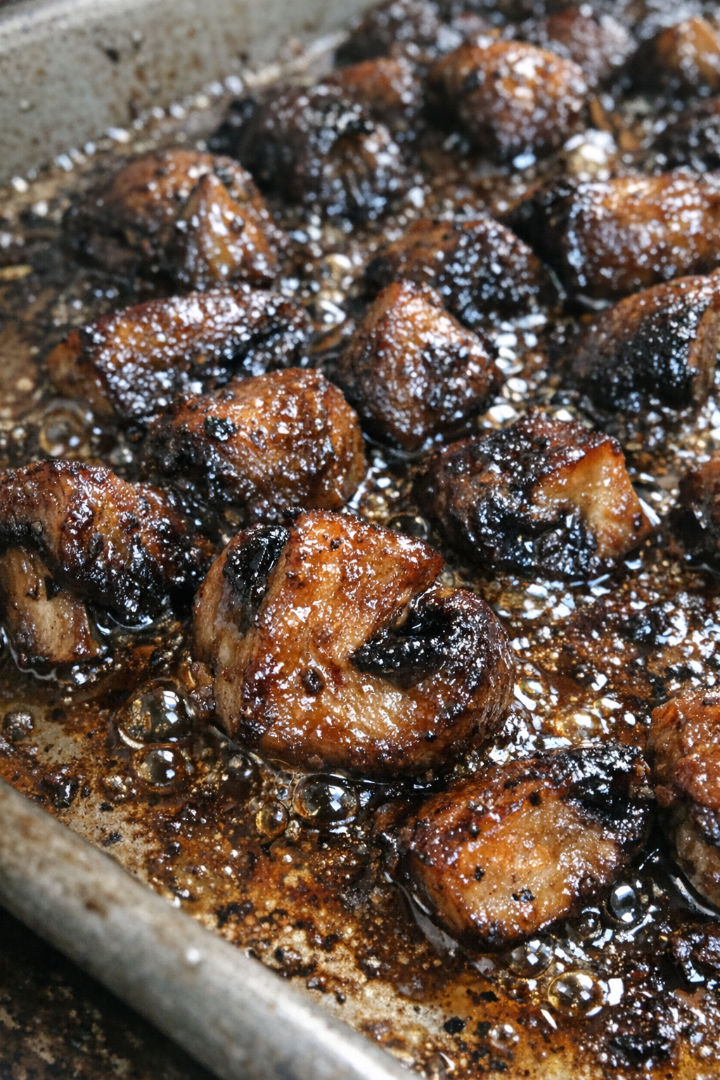 Glistening umami-rich bites bubbling on a baking sheet