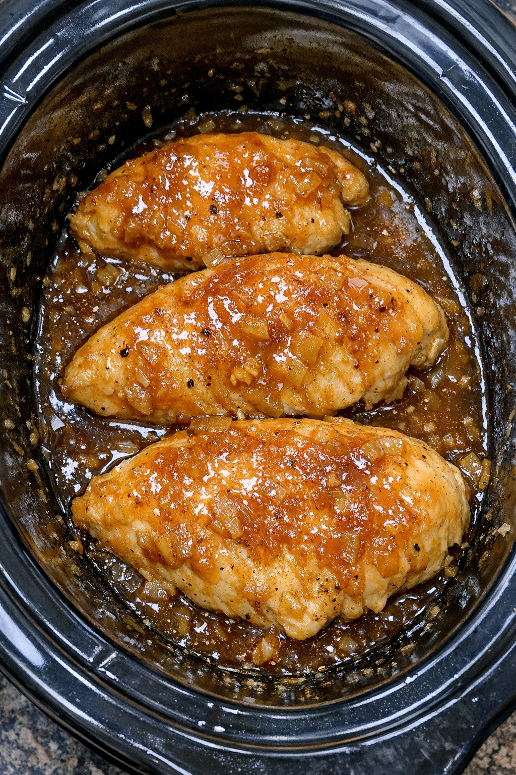 Finished slow cooker apricot chicken in black slow cooker