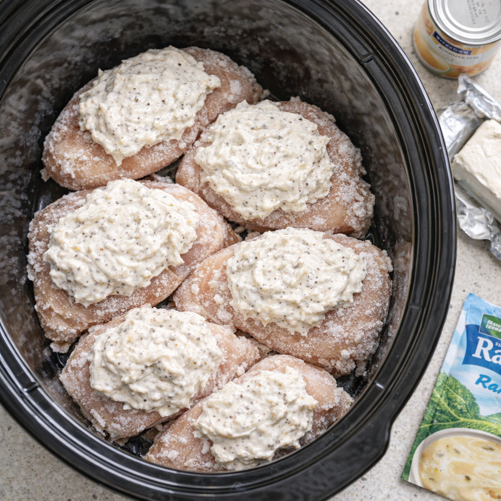 Frozen chicken breasts arranged in a slow cooker