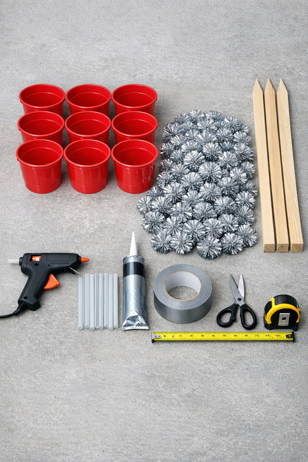 Red buckets, silver pom-poms, adhesive, and support materials laid out for the project