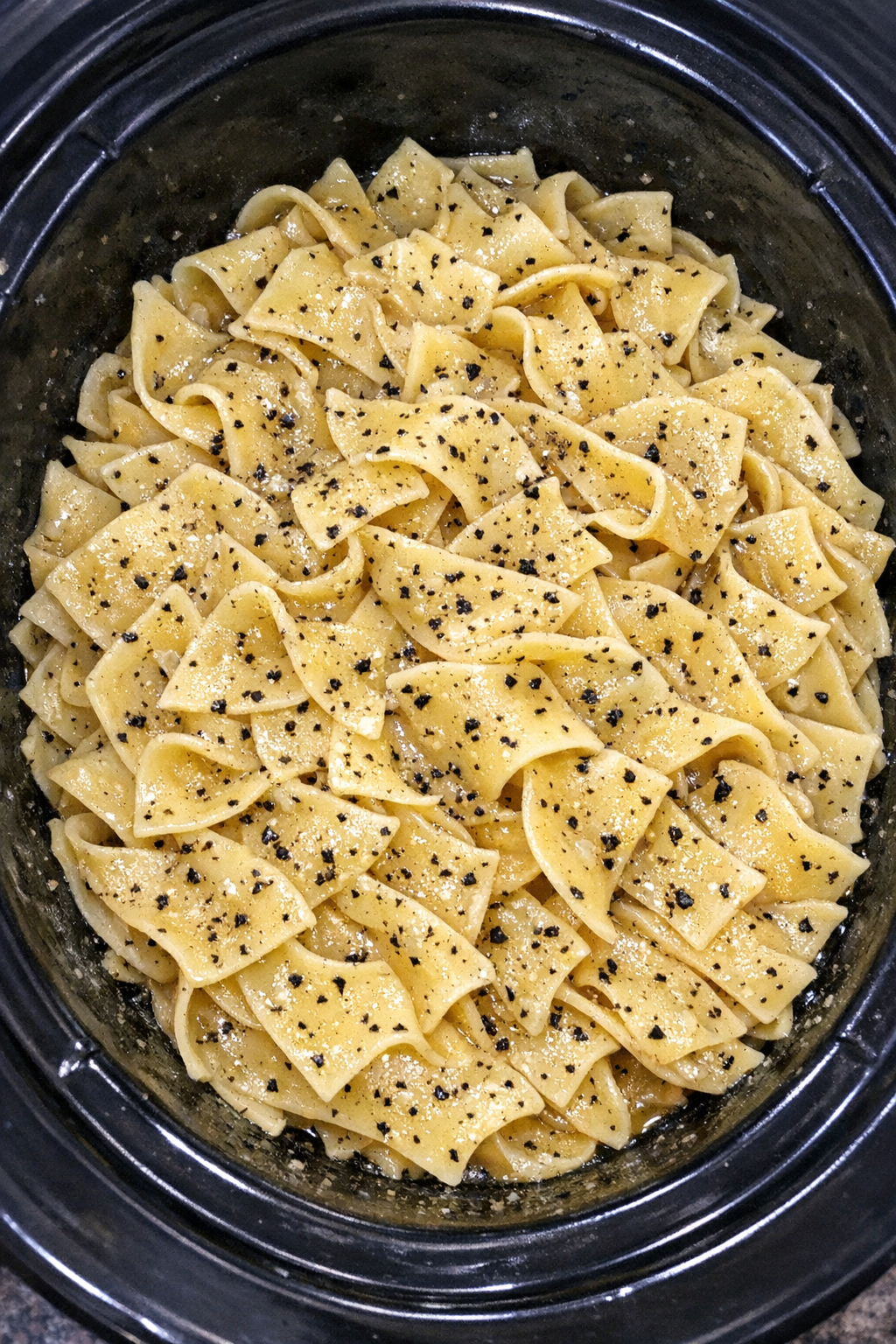 Slow cooker Amish black pepper noodles in a black slow cooker
