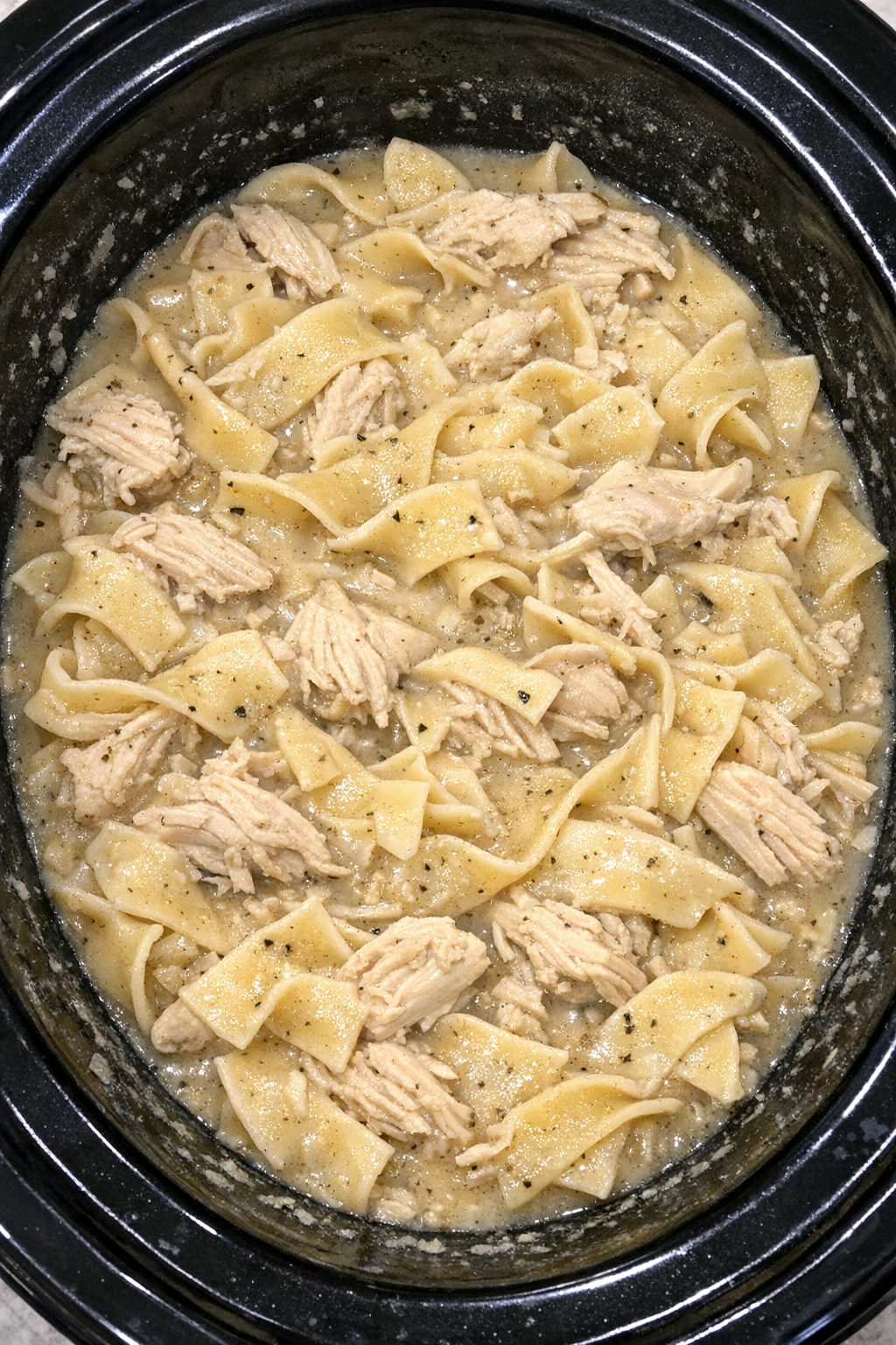 Slow cooker Amish chicken noodle pot in a black slow cooker